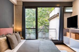 uma sala de estar com um sofá e uma grande janela em Unique Roma Apartments S51 By MrW em Cidade do México