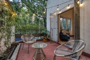 un patio con 2 sillas y una mesa en Unique Roma Apartments S51 By MrW en Ciudad de México