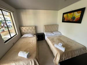 2 camas en una habitación pequeña con ventana en Finca Hotel Villa Celeste, en Quimbaya
