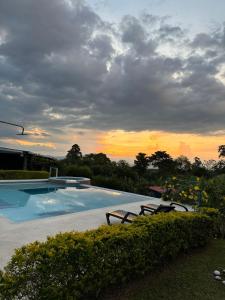 una gran piscina con puesta de sol en el fondo en Finca Hotel Villa Celeste, en Quimbaya