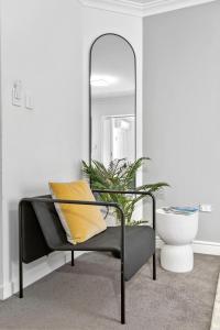 a mirror sitting next to a chair in a room at Mounts Bay Charm 1br Urban Escape in Perth