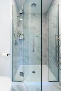 a shower with a glass door in a bathroom at 3 Bedroom Hagley Park Paradise in Christchurch