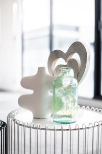 Un frasco de vidrio y un bol encima de una mesa. en Mega Style Apartments Capri, en Melbourne