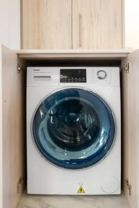 a washing machine with a blue in a cabinet at 3 Bedroom Hagley Park Paradise in Christchurch