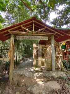 a wooden gate with a sign in a forest at Alojamiento Natural La Cueva de Morgan San Rafael in San Rafael