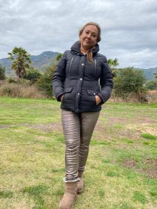 a woman standing in a field wearing a jacket at Casa de Campo in Santa Cruz