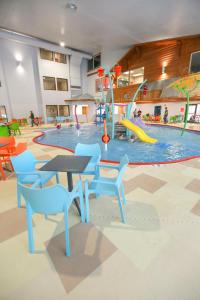 a playground with a table and chairs in front of a pool at Rapid River Lodge in Baxter