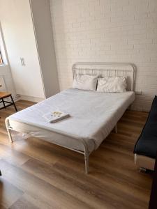 a white bed with a tray on top of it at H & D Apartments in Melbourne