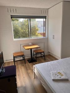 Habitación con cama, mesa y ventana en H & D Apartments, en Melbourne