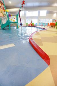 a swimming pool with a slide in a gym at Rapid River Lodge in Baxter