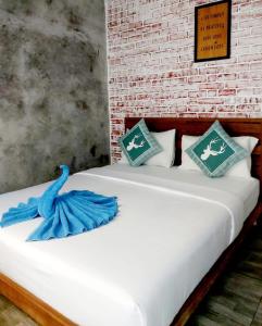 two beds in a room next to a brick wall at Baan Minnie 2 bedroom home 400m from Saikaew beach in Ko Samed