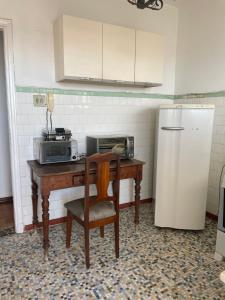 a kitchen with a table with a microwave and a refrigerator at Apart 603 - Centro Histórico in Itu