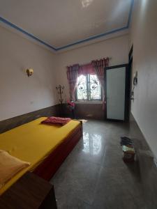 Un dormitorio con una gran cama amarilla y una ventana en Hotel Như Nguyệt, en Việt Yên