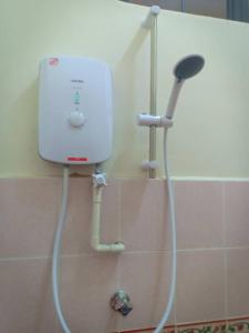 een badkamer met een douche en een witte tank bij Gelama Resort Pasir Panjang in Port Dickson