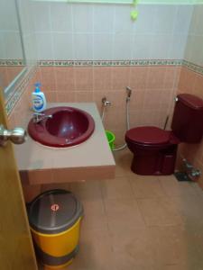 een badkamer met een paarse wastafel en een toilet bij Gelama Resort Pasir Panjang in Port Dickson