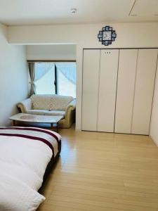 a room with a bed and a couch and a chair at 山中湖リゾートハウス in Yamanakako