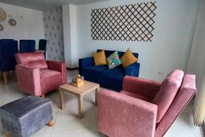 sala de estar con 2 sillas y sofá azul en Confort 301 Apartamento Duitama, en Duitama