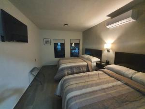 Habitación de hotel con 3 camas y TV de pantalla plana. en FIESTA MIRAMAR, en Ciudad Madero