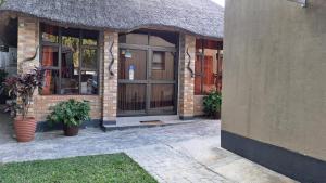 a brick building with a large door and windows at Riverside guesthouse B & B in Katima Mulilo
