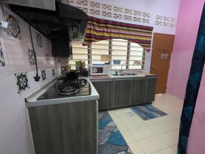 a small kitchen with a stove and a sink at EQ Malay Modest Homestay Port Dickson in Port Dickson