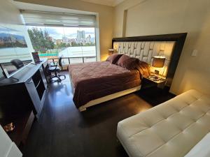 Dormitorio con cama, escritorio y TV en Suite de lujo en excelente sector, netflix, disney plus, en Quito