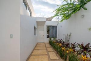 uma casa branca com um caminho e plantas em Casa Caribe Chetumal em Chetumal