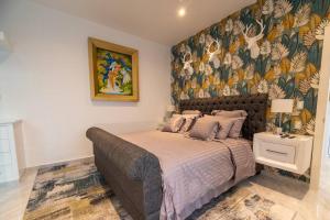 1 dormitorio con 1 cama grande y papel pintado con motivos florales en Casa Caribe Chetumal en Chetumal
