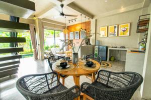 uma sala de jantar com mesa e cadeiras e uma cozinha em Villa Hazel em Dalung