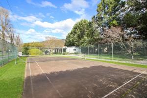 a tennis court in front of a fence at Grevillea Gardens Unit 8 in Bright