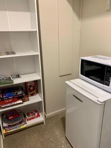 a microwave oven sitting on top of a refrigerator at KG Ensuite in Palmerston North