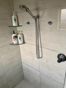 a shower with a shower head in a bathroom at KG Ensuite in Palmerston North