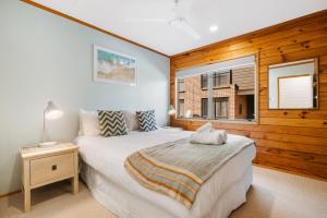 - une chambre avec un grand lit et une fenêtre dans l'établissement The Iconic Kiwi Bach, Full Site Downtown Mount, à Mount Maunganui