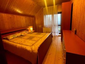 1 dormitorio con cama y ventana grande en Villa M, en Mykulychyn