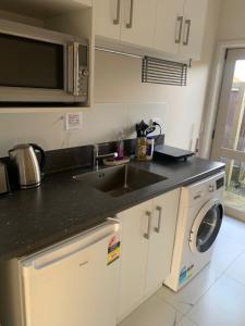 a kitchen with a sink and a washing machine at KG Studio in Palmerston North