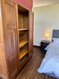 a bedroom with a large wooden cabinet next to a bed at Villa Vallière bed&breakfast in Vallières