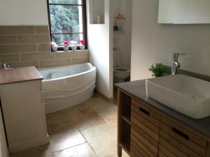 une salle de bain avec une baignoire blanche et un lavabo dans l'établissement Mas provençal dans un lieu exceptionnel, à Bollène