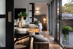 a dining room with a table and chairs and a balcony at Negroni Lane in Hepburn Springs +8 photos