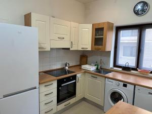 una cucina con armadi bianchi, lavandino e lavastoviglie di Ewa Apt - 3-Bedrooms Apt near Sliema - St Julians Seafront a Il-Gżira