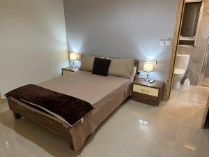 a bedroom with a bed and two night stands with lamps at Ewa Apt - 3-Bedrooms Apt near Sliema - St Julians Seafront in Il-Gżira