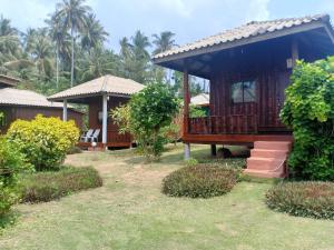 a small house with a porch in a yard at Happy Days Resort in Ko Mak