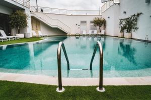 a large swimming pool in a building with chairs at Hotel Majesty Alberobello in Alberobello