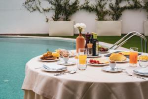 a table with food and drinks next to a pool at Hotel Majesty Alberobello in Alberobello