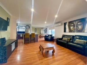 a living room with a couch and a table at Marcoola House, Pet Friendly, Sunshine Coast in Marcoola