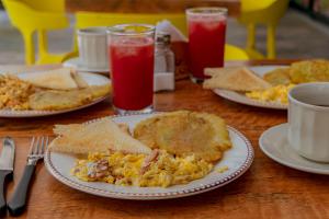 a table with plates of eggs and toast and drinks at Hotel Marco Polo Rodadero in Santa Marta