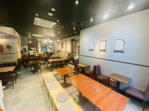 a restaurant with wooden tables and chairs in a room at APA Hotel Nambaminami Ebisucho Eki Shinsekai in Osaka