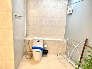 a bathroom with a toilet with a blue seat at Hotel La Villa Khon Kaen in Khon Kaen