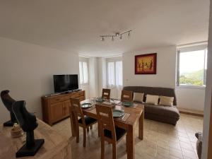 een woonkamer met een tafel en een bank bij Maison En Pierre Dans Village Calme in Monacia-dʼAullène