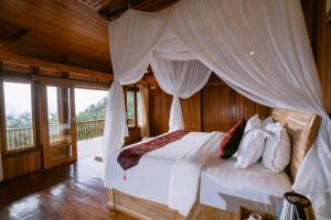 a bedroom with a bed with a canopy at Munduk Menir Villas in Munduk