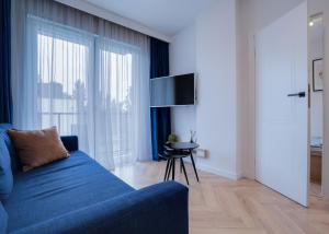 a living room with a blue couch and a table at Apartament Premium, 15min od Rynku, parking w cenie in Wrocław