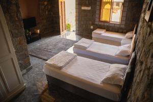 three beds in a room with a door at nbz chalet Jasmine stairs in Al ‘Aqar +15 photos